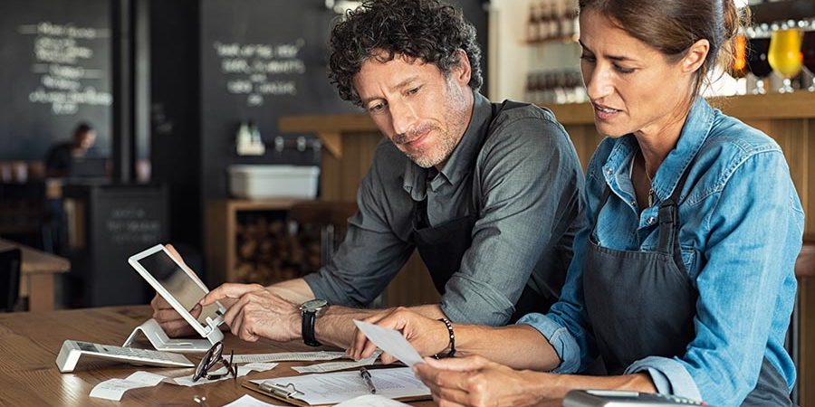 Man and woman sitting in cafeteria discussing finance for the mo Restaurant management