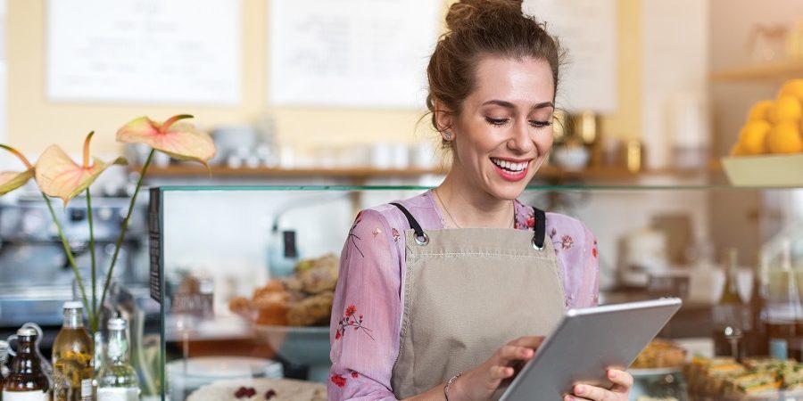 Young woman using digital tablet in coffee shop web-based reporting tools