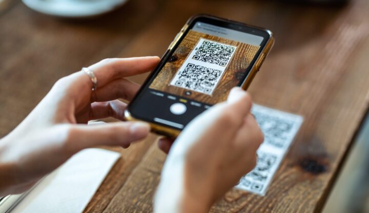 closeup of customer scanning qr code for mobile order and pay at table