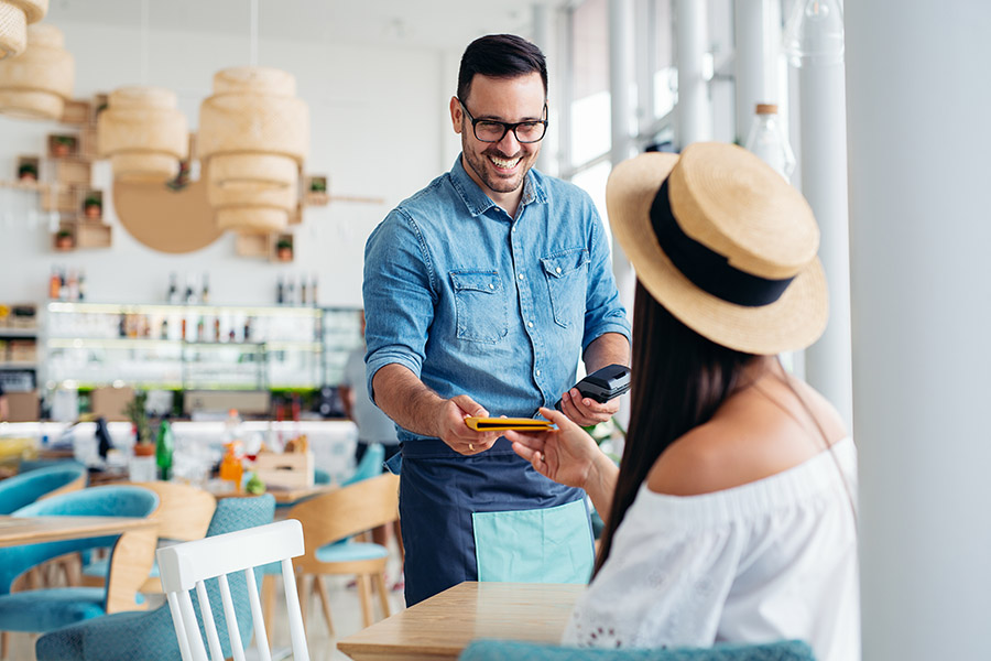 A young and attractive woman paying the bill in a restaurant
