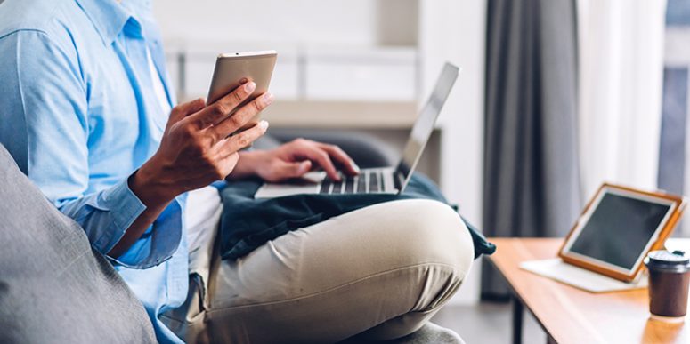 Young smiling asian man relaxing using laptop computer working a Young smiling asian man relaxing using laptop computer working a