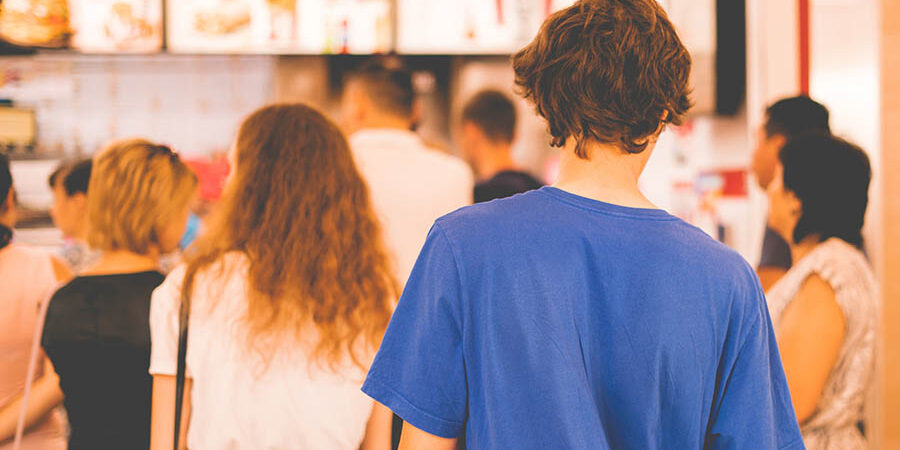 young teenager standing in a queue to receive the fastfood package